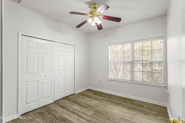 unfurnished bedroom featuring a closet, ceiling fan, and light wood-type flooring