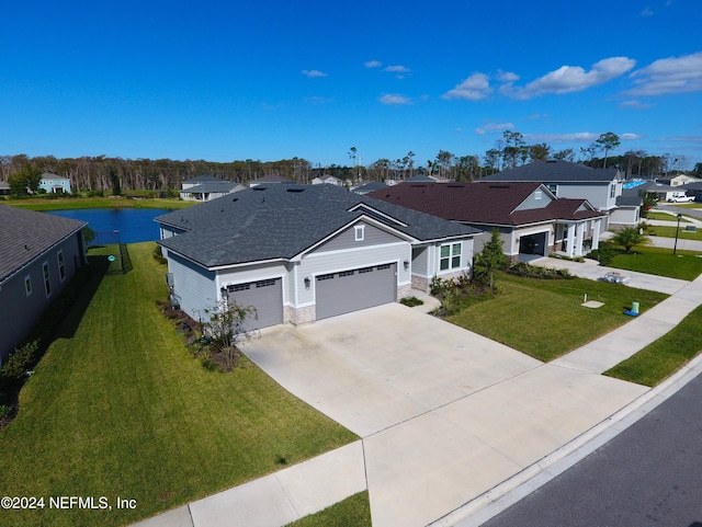 view of front facade with a garage, a front lawn, and a water view