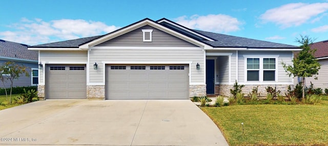 craftsman house featuring a front yard and a garage