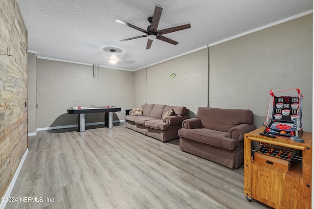 living room featuring light hardwood / wood-style floors, crown molding, a textured ceiling, and ceiling fan