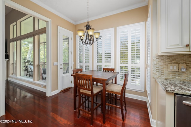 dining room featuring a wealth of natural light, ornamental molding, an inviting chandelier, and dark hardwood / wood-style flooring