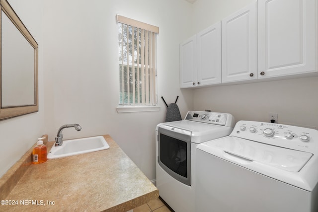 laundry area with independent washer and dryer, cabinets, sink, and light tile patterned floors