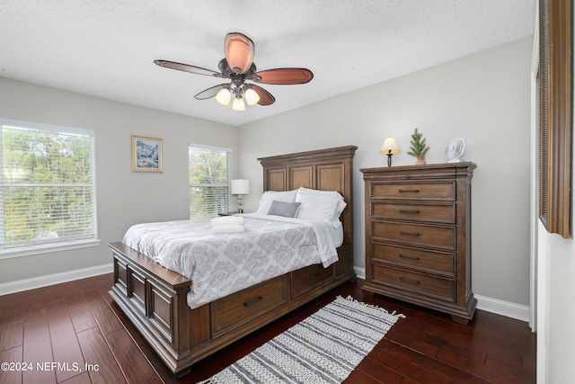 bedroom with dark wood-type flooring, a textured ceiling, and ceiling fan