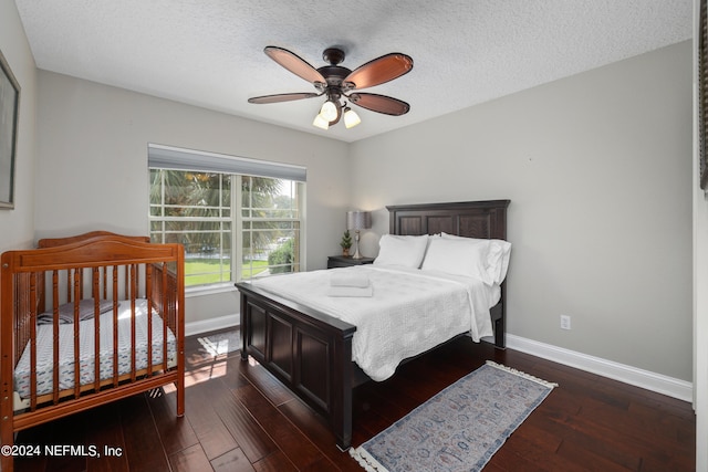 bedroom featuring ceiling fan, a textured ceiling, and dark hardwood / wood-style flooring