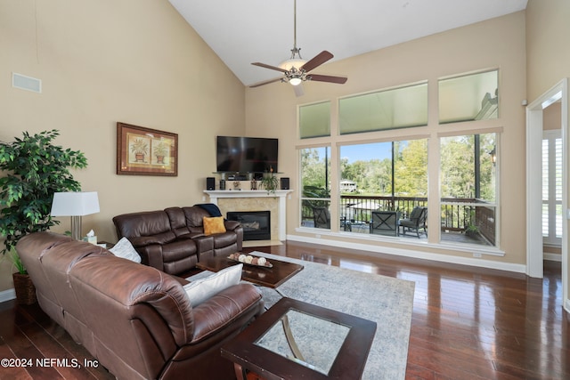 living room featuring dark wood-type flooring, a fireplace, high vaulted ceiling, and ceiling fan