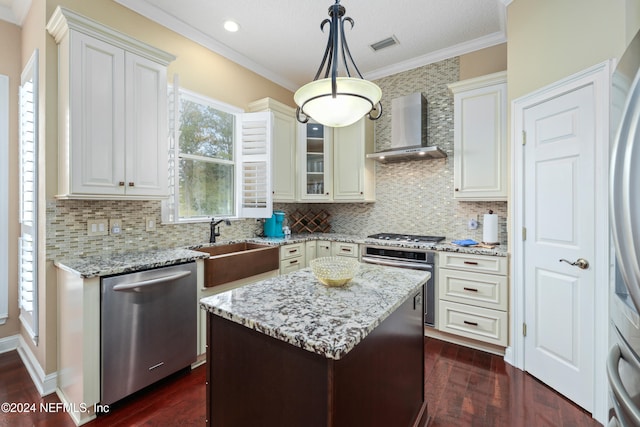 kitchen with wall chimney range hood, dark hardwood / wood-style floors, stainless steel appliances, and pendant lighting