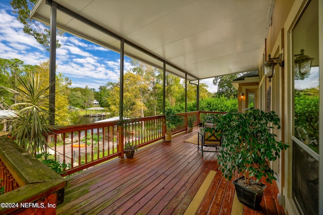 sunroom / solarium with a water view and plenty of natural light