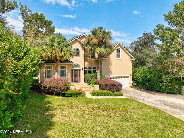 view of front of property with a front yard and a garage