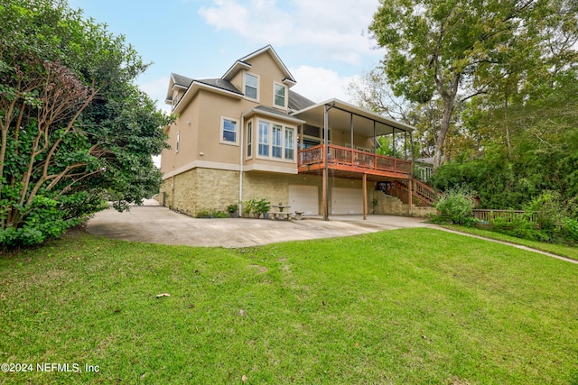 back of house with a wooden deck, a yard, and a garage