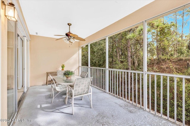 unfurnished sunroom featuring ceiling fan and plenty of natural light