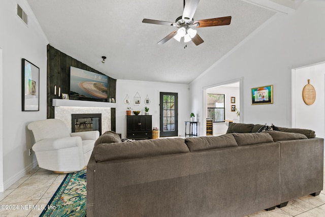 tiled living room with a textured ceiling, lofted ceiling with beams, a fireplace, and ceiling fan