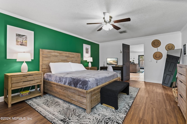 bedroom with crown molding, a textured ceiling, light hardwood / wood-style floors, and ceiling fan