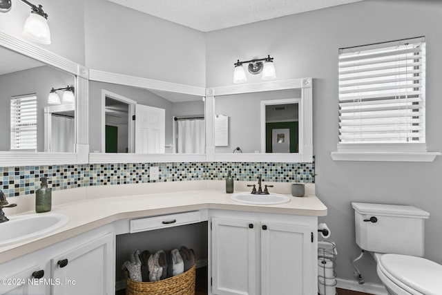 bathroom with vanity, toilet, and plenty of natural light