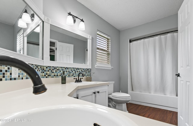 full bathroom featuring tasteful backsplash, shower / tub combo, a textured ceiling, toilet, and vanity