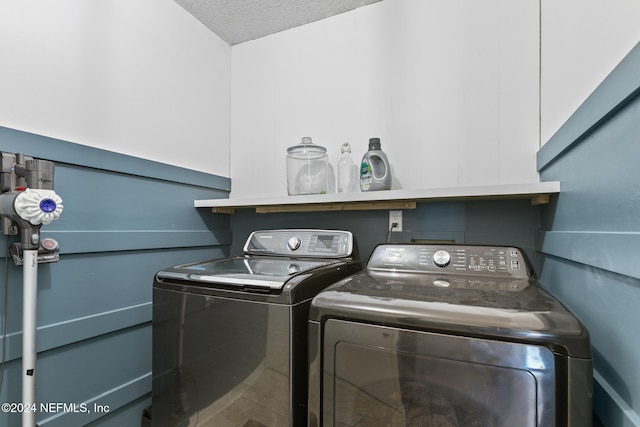 washroom featuring independent washer and dryer and a textured ceiling