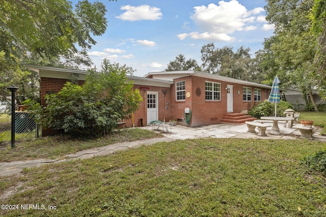 back of property with a patio and a lawn