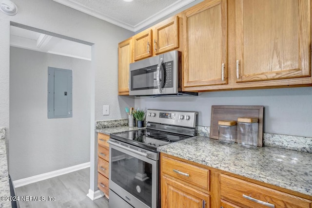 kitchen featuring light hardwood / wood-style flooring, ornamental molding, electric panel, appliances with stainless steel finishes, and light stone counters