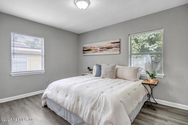 bedroom featuring hardwood / wood-style flooring and multiple windows