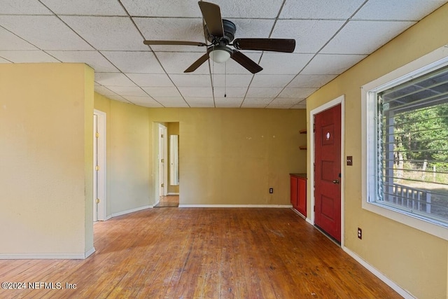 spare room featuring ceiling fan, a paneled ceiling, and hardwood / wood-style floors