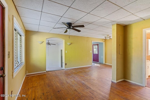 unfurnished room featuring ceiling fan, wood-type flooring, and a drop ceiling