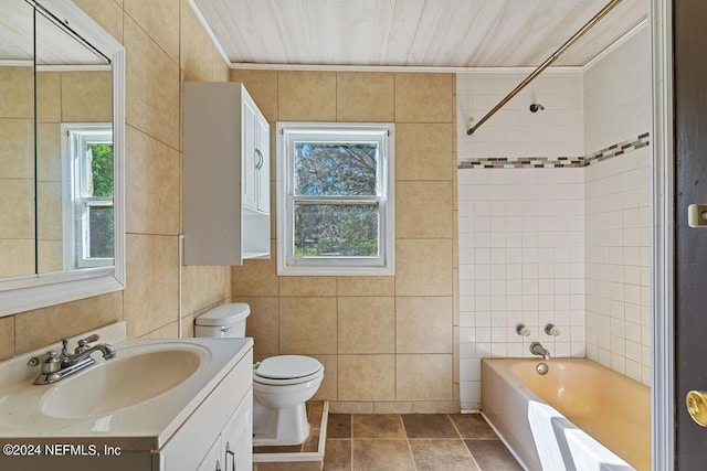 full bathroom featuring vanity, tile walls, toilet, and tub / shower combination