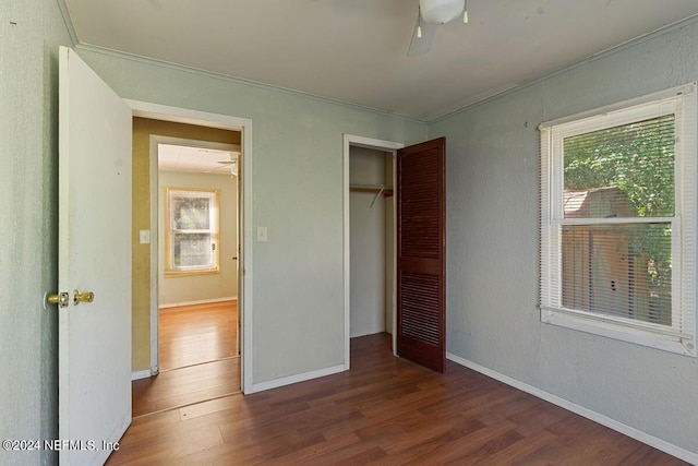 unfurnished bedroom featuring a closet, multiple windows, and wood-type flooring