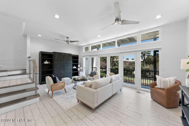 living room featuring ceiling fan, light hardwood / wood-style flooring, and french doors