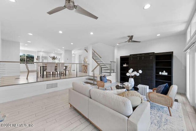 living room with ceiling fan and light wood-type flooring