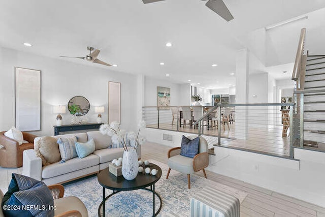 living room featuring ceiling fan and light wood-type flooring