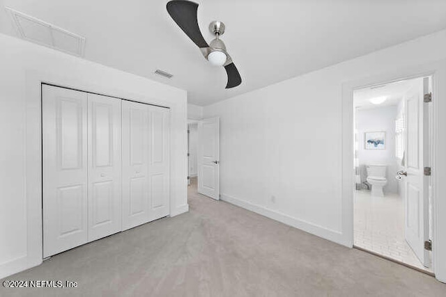 unfurnished bedroom featuring a closet, ensuite bathroom, and ceiling fan