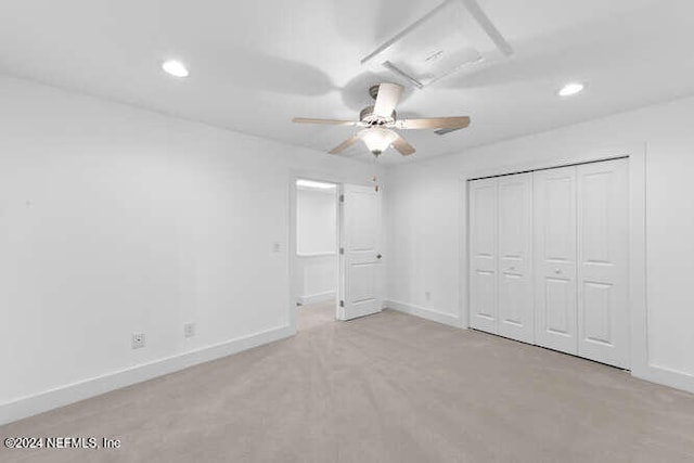 unfurnished bedroom with a closet, light colored carpet, and ceiling fan