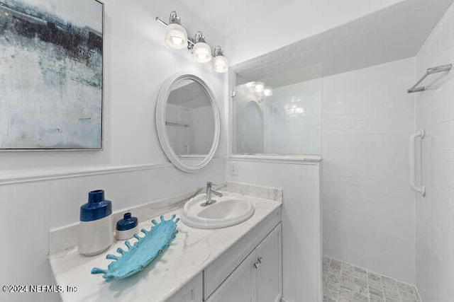 bathroom featuring a tile shower and vanity