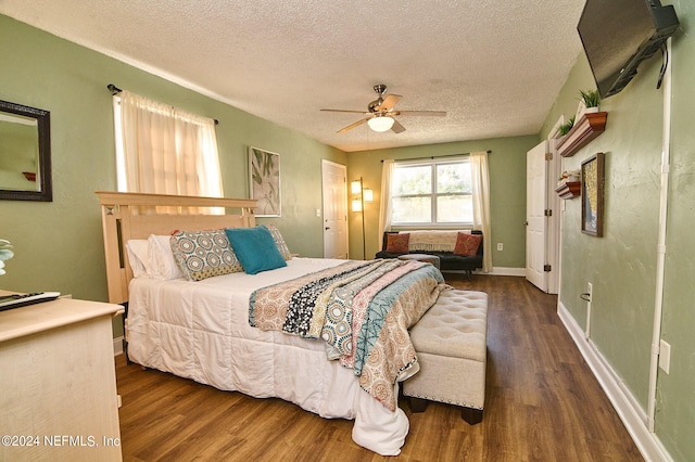 bedroom with ceiling fan, a textured ceiling, and dark hardwood / wood-style floors