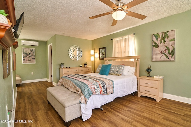 bedroom with wood-type flooring, a wall mounted air conditioner, ceiling fan, and a textured ceiling