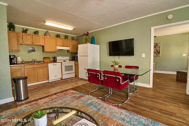 kitchen with crown molding, wood-type flooring, a textured ceiling, and white appliances