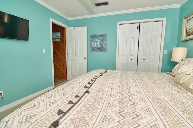 bedroom featuring ornamental molding, a textured ceiling, and a closet