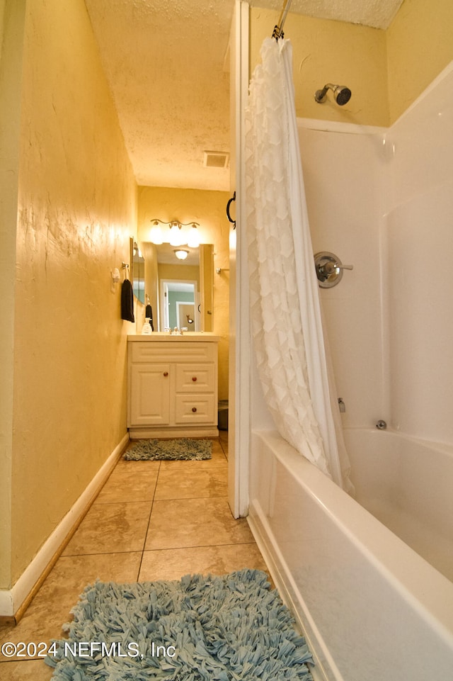 bathroom with shower / tub combo, vanity, a textured ceiling, and tile patterned flooring