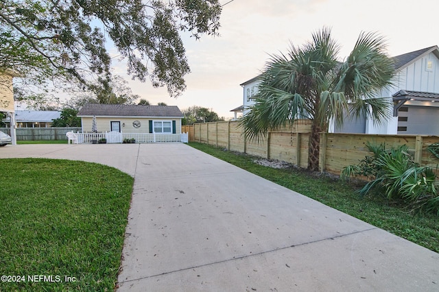 view of front of home featuring a lawn and an outdoor structure