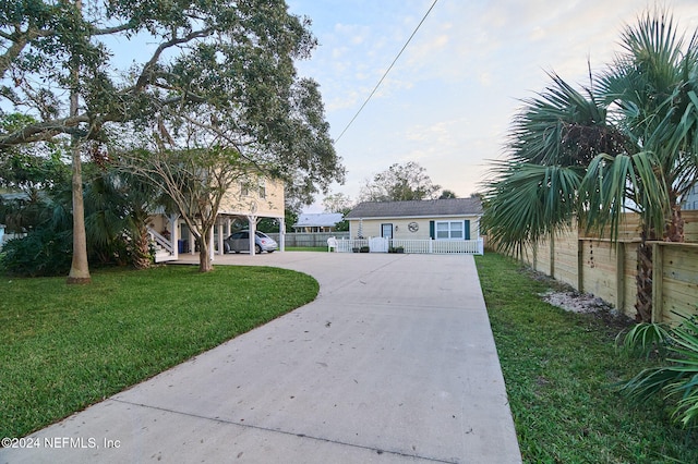 view of front of house with a front lawn, an outdoor structure, and a carport