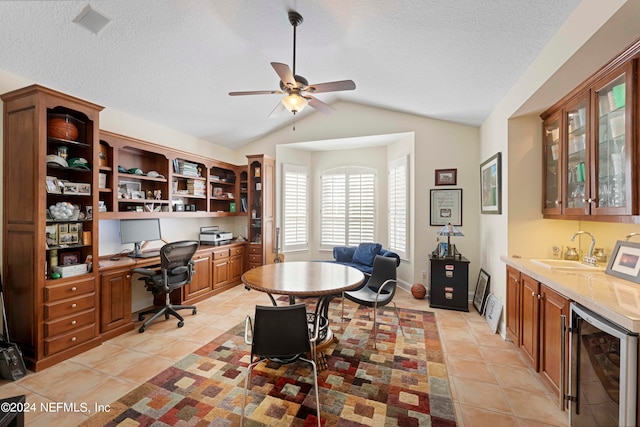 tiled office featuring a textured ceiling, vaulted ceiling, ceiling fan, sink, and wine cooler