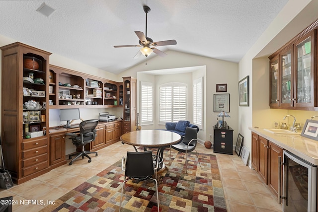 office area with lofted ceiling, wine cooler, wet bar, a ceiling fan, and a sink
