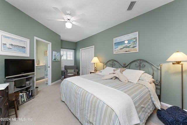 bedroom with visible vents, a closet, baseboards, light colored carpet, and ensuite bathroom