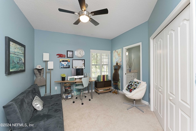 carpeted home office with a textured ceiling and a ceiling fan