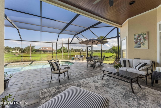 view of patio / terrace with glass enclosure, an outdoor pool, ceiling fan, and an outdoor living space