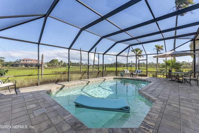 outdoor pool featuring glass enclosure, outdoor dining area, and a patio