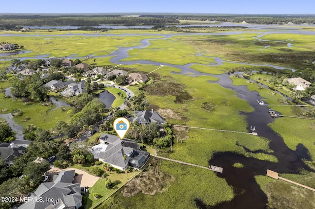 drone / aerial view featuring golf course view, a water view, and a residential view