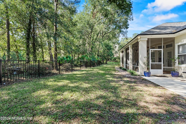 view of yard with a sunroom and a patio