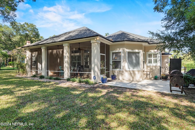 back of house featuring a sunroom, a patio, and a lawn