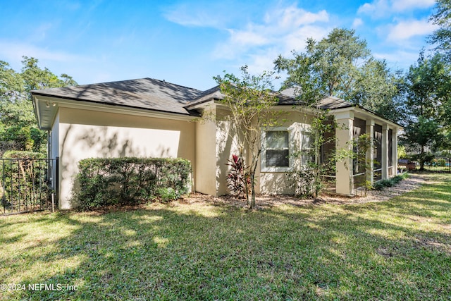 view of property exterior with a lawn and a sunroom