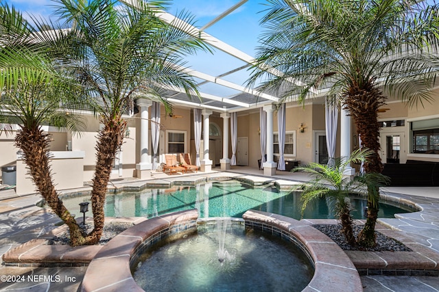 view of swimming pool featuring a lanai, an in ground hot tub, and a patio